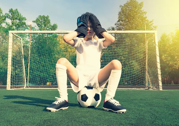 Triste portero junior de fútbol. Chico decepcionado en un kit de ropa deportiva de portero blanco con manos en la cabeza. Junior equipo de fútbol juvenil perdiendo gol —  Fotos de Stock