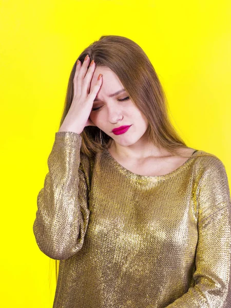 Frustrée jeune et belle femme semble bouleversée, déprimée et tient sa main de la tête sur un fond jaune — Photo