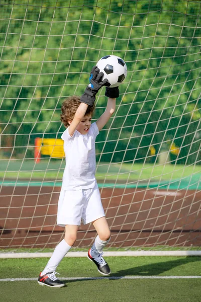 Summer soccer tournament for young kids. football club. emotions and joy of the game. Young goalie. Boy goalkeeper in football sportswear on stadium with ball. Sport concept. selective focus