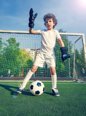 Küçük çocuklar için yaz futbol turnuvası. Futbol kulübü. Oyunun heyecanı ve neşesi. Genç kaleci. Stadyumda futbol takımının erkek kalecisi. Spor konsepti. seçici odak.