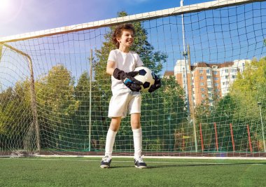 Küçük çocuklar için yaz futbol turnuvası. Futbol kulübü. Oyunun heyecanı ve neşesi. Genç kaleci. Çocuklar, futbol şampiyonu. Stadyumda futbol takımının erkek kalecisi. Spor konsepti.