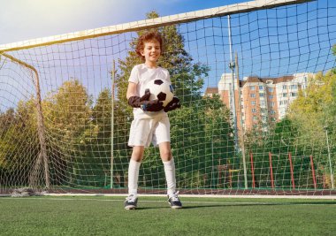 Küçük çocuklar için yaz futbol turnuvası. Futbol kulübü. Oyunun heyecanı ve neşesi. Genç kaleci. Çocuklar, futbol şampiyonu. Stadyumda futbol takımının erkek kalecisi. Spor konsepti.