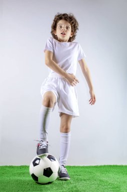 Siyah saçlı küçük bir çocuk futbol topuyla oynuyor. Stresli, utangaç ve şaşırmış bir yüz ifadesi. Kızgın ve sinirli. Hata için korku ve üzüntü.