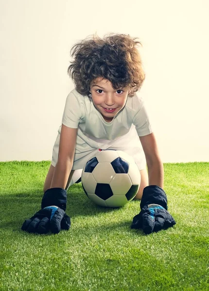 儿童足球课程 一个长着足球的可爱的毛茸茸的男孩站起来在草皮的工作室背景上的画像 年轻守门员 — 图库照片