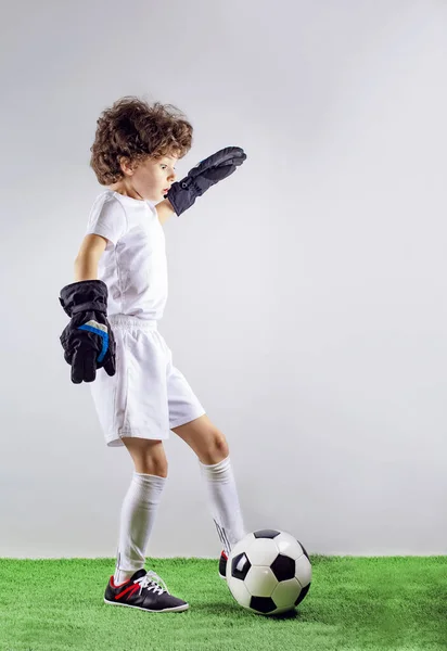 儿童足球冠军 男孩守门员 在足球运动服中有着惊讶的脸 灰色背景的球 体育概念 复制空间 — 图库照片