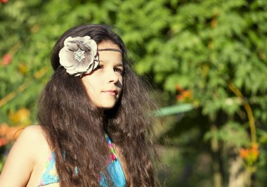 Sıcak bir yaz gününde, egzotik yeşilliklerin arasında mavi mayolu güzel bir kız. Güzel bir kızın güzel portresi. Boşluğu kopyala