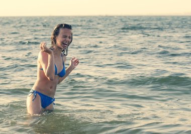 Koyu renk saçlı, ıslak bir kadının portresi. Güneşin battığı yaz akşamında mayo giymiş genç bir kadın. Boşluğu kopyala