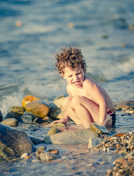 Trillende Kleine Jongen Zit Een Kiezelstrand Buurt Van Het Water — Stockfoto