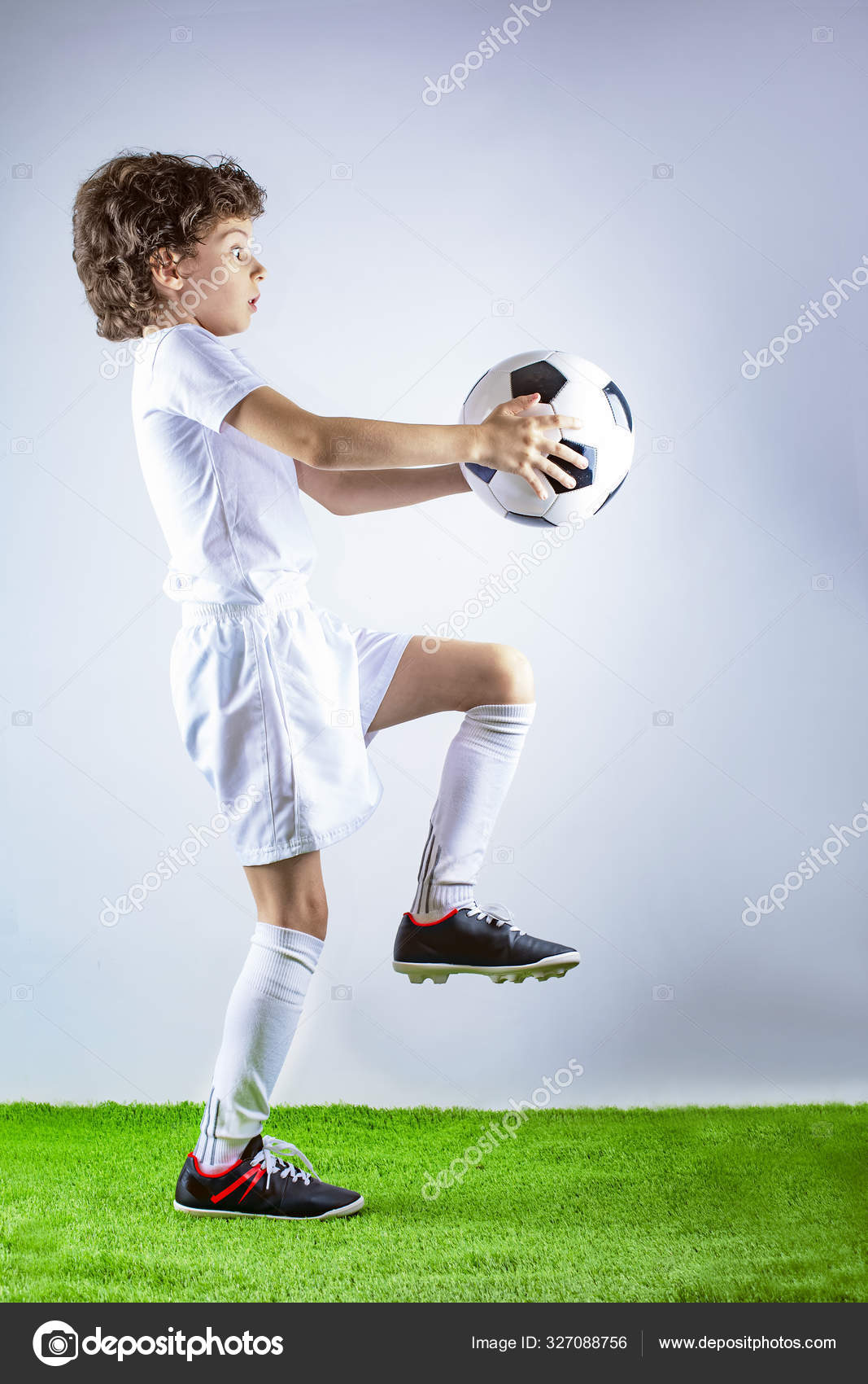 フルプロフィール長いですショットの小さなサッカー選手ジャグリングaフットボール孤立した上灰色の背景 ストック写真 C Kravik93 327088756