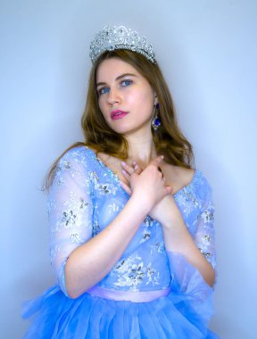 Mavi elbiseli mavi gözlü güzel bir kız. Prenses tacını takmış bir kız..