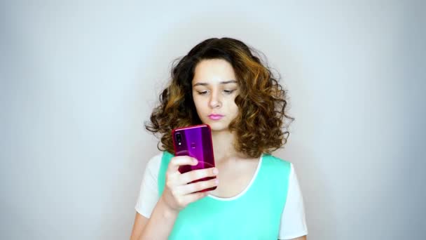 Hermosa Chica Joven Usando Teléfono Inteligente Sobre Fondo Blanco — Vídeo de stock