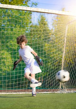 Çocukların futbol maçı. Futbol sahasındaki küçük çocukların maçı. Genç kaleci. Çocuklar, futbol şampiyonu. Stadyumda futbol takımının erkek kalecisi. Spor konsepti.