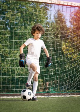 Küçük çocuklar için yaz futbol turnuvası. Futbol kulübü. Oyunun heyecanı ve neşesi. Genç kaleci. Çocuklar, futbol şampiyonu. Stadyumda futbol takımının erkek kalecisi. Spor konsepti.