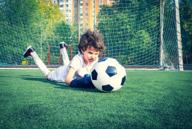 Genç futbol kalecisi kurtarmayı deniyor. Eldivenli küçük bir kaleci. Çocuklar, futbol şampiyonu. Stadyumda futbol takımının erkek kalecisi. Spor konsepti. Seçici odak.