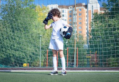 Küçük çocuklar için yaz futbol turnuvası. Futbol kulübü. Oyunun heyecanı ve neşesi. Genç kaleci. Çocuklar, futbol şampiyonu. Stadyumda futbol takımının erkek kalecisi. Spor konsepti.