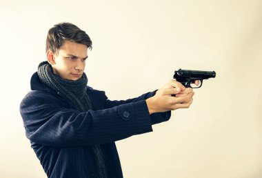 Adam kamerayı kapatırken tabancayla arka planda izole edilmiş. Boşluğu kopyala