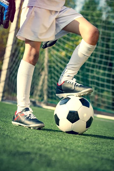 Futbol, futbol başladı. Adam çimlerin üzerinde bir futbol topunu kontrol ediyor. Küçük çocuklar için yaz futbol turnuvası. Stadyumda futbol takımının erkek kalecisi. Spor konsepti.