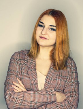 Kareli ceketli bir kızın portresi, arka planda, izole. Doğal makyajlı güzel bir genç kadın..