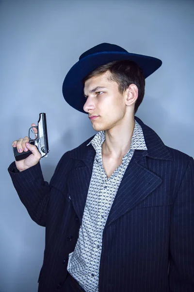 Joven Asesino Con Sombrero Sosteniendo Arma Mirando Pensativamente Lejos Cámara — Foto de Stock