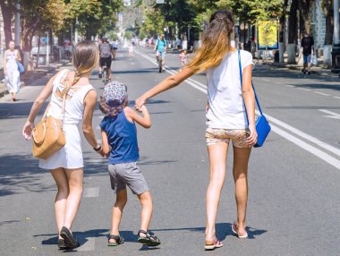 Bir çocuk onun ablası ile bir sıcak yaz gününde sokakta yürüyor. Sevgi ve destek için küçük kız kardeşlerin ifadesi. Anne, kızı ve oğlu aşk.