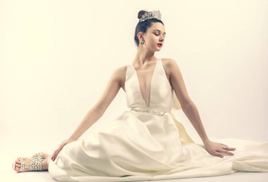 Çok güzel, çok genç bir gelin, büyük göğüsleri, lüks bir gelinliği ve tacı var. Boşluğu kopyala