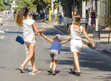 Bir çocuk onun ablası ile bir sıcak yaz gününde sokakta yürüyor. Sevgi ve destek için küçük kız kardeşlerin ifadesi. Anne, kızı ve oğlu aşk.