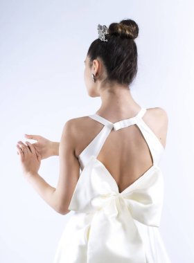 Yüzükler gelinin elinde, kız yüzüklere bakıyor. Gelin olarak taç ve saç stili. Güzel Gelinin yakın portresi. Arka plan