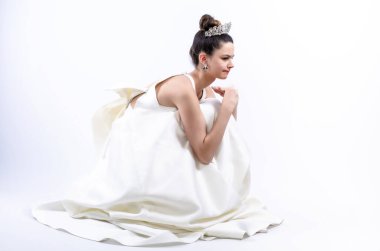 Üzgün ve agresif bir şekilde koyu renk saçlı gelin yerde oturuyor ve yüzüğünü çıkartıyor. Düğün gününde tereddüt ediyor. Boşluğu kopyala