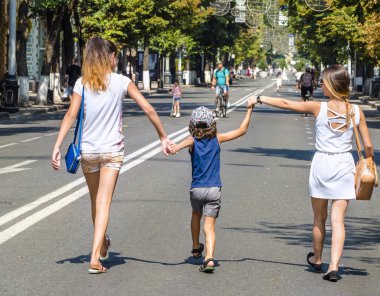 Bir çocuk onun ablası ile bir sıcak yaz gününde sokakta yürüyor. Sevgi ve destek için küçük kız kardeşlerin ifadesi. Anne, kızı ve oğlu aşk.