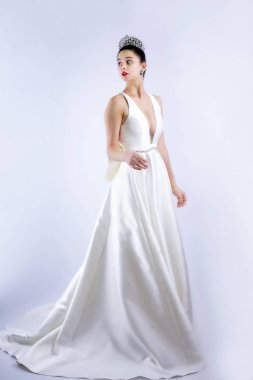 Genç, şok olmuş gelin gri arka planda tek başına dönüyor. Boşluğu kopyala