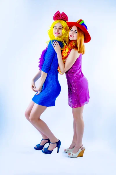 Atraktivní hravé mladé ženy připravené na karnevalové večírky. Životní styl a koncept přátelství: skupina dvou přítelkyň. Izolováno na šedé — Stock fotografie