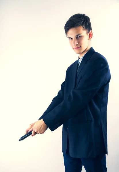 action portrait of serious and attractive hitman or special agent man holding gun reloading the weapon isolated on light background in secret service Hollywood style movie