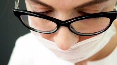 Ameliyat sırasında steril maske takmış bir cerrahın yüzüne yakın çekim. Ameliyat masasının yanındaki cerrahlar. İş sırasında güzellik uzmanı.