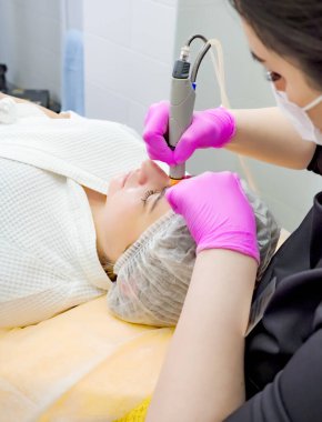 Profesyonel kadın kozmetolojist kozmetoloji kliniğinde hidrakiyal prosedür uyguluyor. Doktor elektrikli süpürge kullan. Yenilenme ve susuzluk. Kozmetoloji