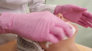 Kanepede gözleri kapalı yatan beyaz şapkalı bir manken. Kuyrukluyıldız prosedürü bekleniyor.