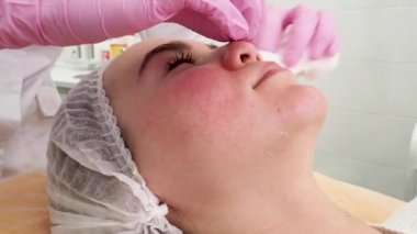 Kanepede gözleri kapalı yatan beyaz şapkalı bir manken. Kuyrukluyıldız prosedürü bekleniyor.