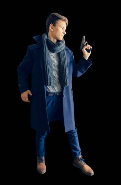 Elinde silah tutan palto ve eşarplı genç bir polisin yan görüntüsü. Özel operasyon. İzole edilmiş