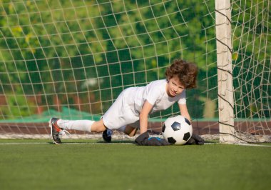 Küçük çocuklar için yaz futbol turnuvası. Futbol kulübü. Oyunun heyecanı ve neşesi. Genç kaleci. Çocuklar, futbol şampiyonu. Stadyumda futbol takımının erkek kalecisi. Spor konsepti.