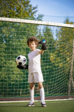 Çocuklar futbol şampiyonudur. Futbol takımının kalecisi. Stadyumun müthiş bir manzarası var. Atletik ve atletik öfke konsepti.