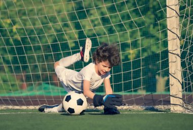 Küçük çocuklar için yaz futbol turnuvası. Futbol kulübü. Oyunun heyecanı ve neşesi. Genç kaleci. Çocuklar, futbol şampiyonu. Stadyumda futbol takımının erkek kalecisi. Spor konsepti.