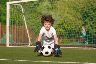 Küçük çocuklar için yaz futbol turnuvası. Futbol kulübü. Oyunun heyecanı ve neşesi. Genç kaleci. Çocuklar, futbol şampiyonu. Stadyumda futbol takımının erkek kalecisi. Spor konsepti.