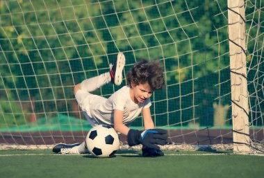 Küçük çocuklar için yaz futbol turnuvası. Futbol kulübü. Oyunun heyecanı ve neşesi. Genç kaleci. Çocuklar, futbol şampiyonu. Stadyumda futbol takımının erkek kalecisi. Spor konsepti.