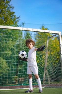 Çocuklar futbol şampiyonudur. Futbol takımının kalecisi. Stadyumun müthiş bir manzarası var. Atletik ve atletik öfke konsepti.