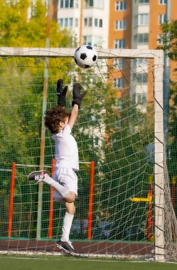 Küçük çocuklar için yaz futbol turnuvası. Futbol kulübü. Oyunun heyecanı ve neşesi. Genç kaleci. Çocuklar, futbol şampiyonu. Stadyumda futbol takımının erkek kalecisi. Spor konsepti.