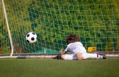 Genç futbolcu. Beyazlar içinde spor giyinmiş hayal kırıklığına uğramış bir çocuk. Kaleci dostluk maçında bir gol kaçırdı..