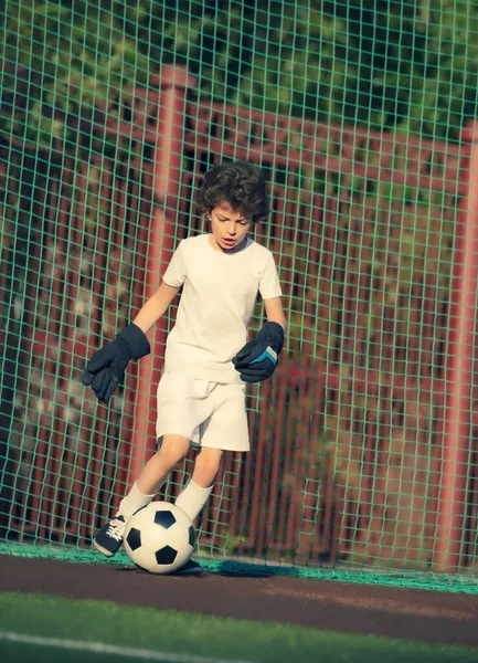 Summer soccer tournament for young kids. football club. emotions and joy of the game. Young goalie. Kids - soccer champion. Boy goalkeeper in football sportswear on stadium with ball. Sport concept.