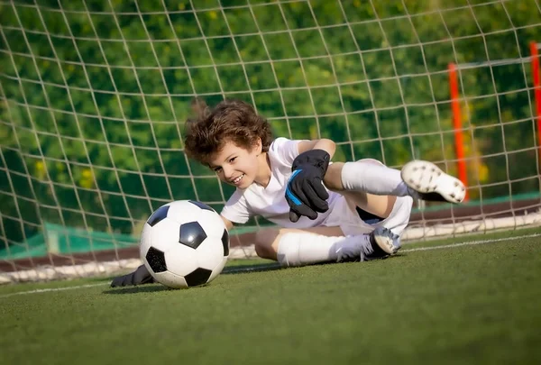 Summer soccer tournament for young kids. football club. emotions and joy of the game. Young goalie. Kids - soccer champion. Boy goalkeeper in football sportswear on stadium with ball. Sport concept.