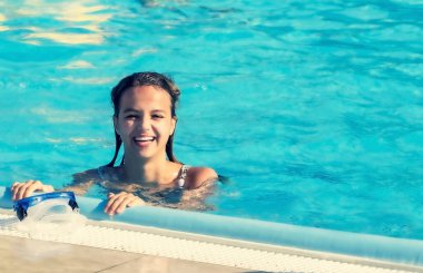 Mutlu gülümseyen kız yaz günü havuzda eğleniyor ve oynuyor. Yazın açık havada. Boşluğu kopyala