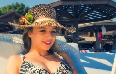 Genç Kadın Freelancer, Okyanus arka planında koltukta oturup, Sahilde Siyah Ekranlı Laptop kullanarak rahatça oturuyor. Kız Freelancer çalışıyor. Ofis dışında çalışma kavramı.