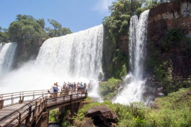 People Walking at Catwalk trail to see San Martin Fall at Iguazu Falls on background clipart